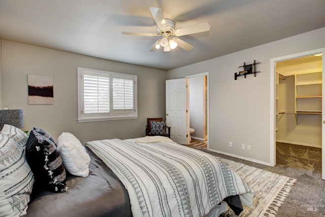 bedroom featuring a ceiling fan, carpet, baseboards, a spacious closet, and connected bathroom