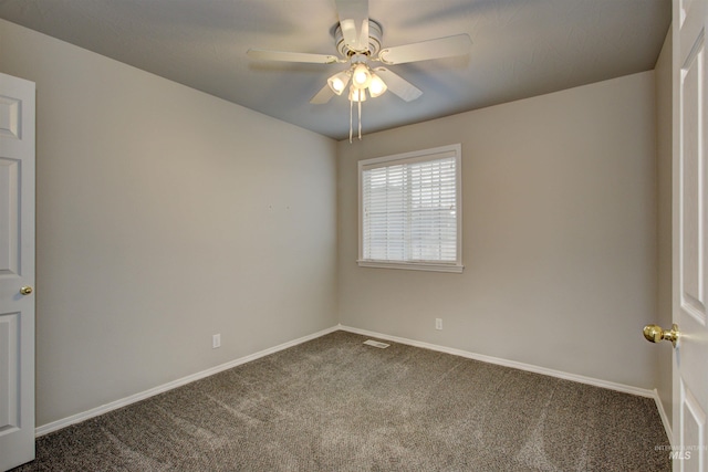 spare room featuring visible vents, baseboards, ceiling fan, and dark carpet