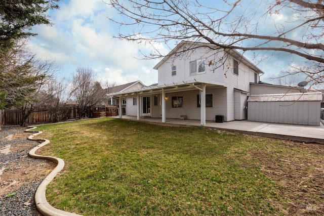 rear view of house with a patio area, a lawn, and fence