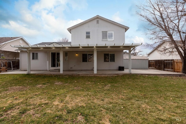 back of house featuring fence, a lawn, and a patio area