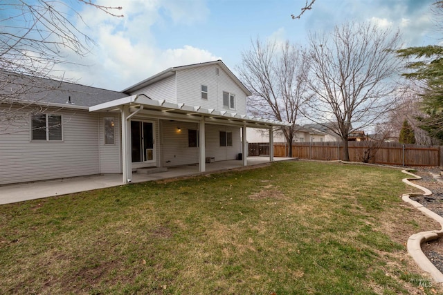 rear view of property with a patio, a lawn, and fence