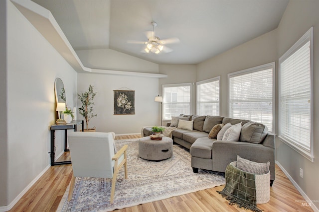 living room featuring vaulted ceiling, a ceiling fan, light wood-style floors, and baseboards