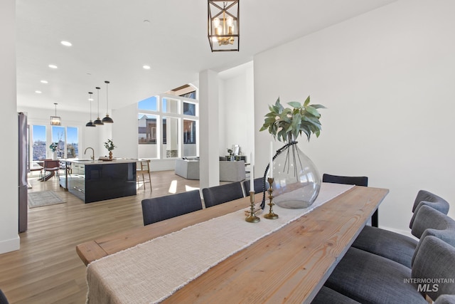 dining area featuring an inviting chandelier, light wood-type flooring, and sink