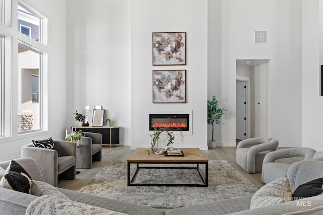 living room featuring a high ceiling and light wood-type flooring