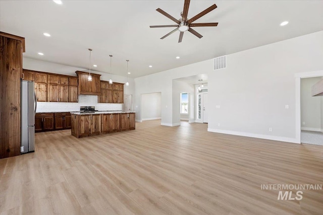 3119 Crescent Moon Rd, Twin Falls, ID 83301 - kitchen with stainless steel appliances, open floor plan, ceiling fan, backsplash, and a kitchen island