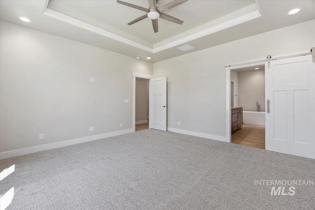 3119 Crescent Moon Rd, Twin Falls, ID 83301 - unfurnished bedroom with a raised ceiling, recessed lighting, a barn door, carpet floors, and connected bathroom