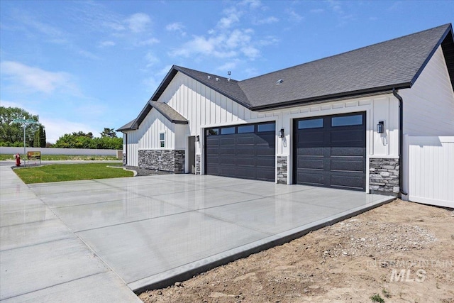 3119 Crescent Moon Rd, Twin Falls, ID 83301 - view of side of home featuring an attached garage, stone siding, concrete driveway, and board and batten siding