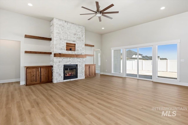 3119 Crescent Moon Rd, Twin Falls, ID 83301 - unfurnished living room featuring a ceiling fan, a stone fireplace, light wood-style floors, a high ceiling, and recessed lighting