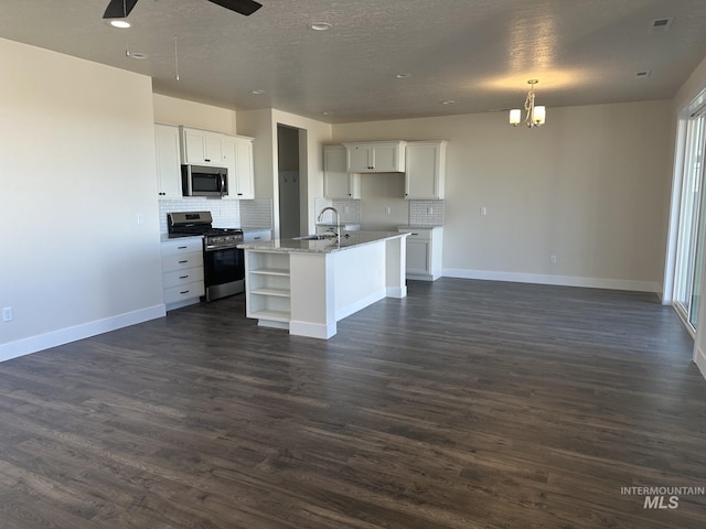 kitchen featuring open floor plan, stainless steel appliances, dark wood finished floors, and white cabinetry