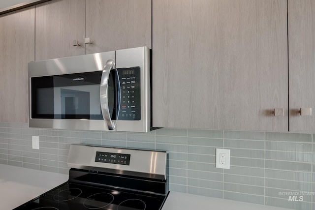 interior details with stainless steel appliances, light countertops, light brown cabinets, and decorative backsplash