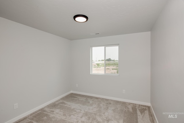 empty room with light carpet, visible vents, and baseboards