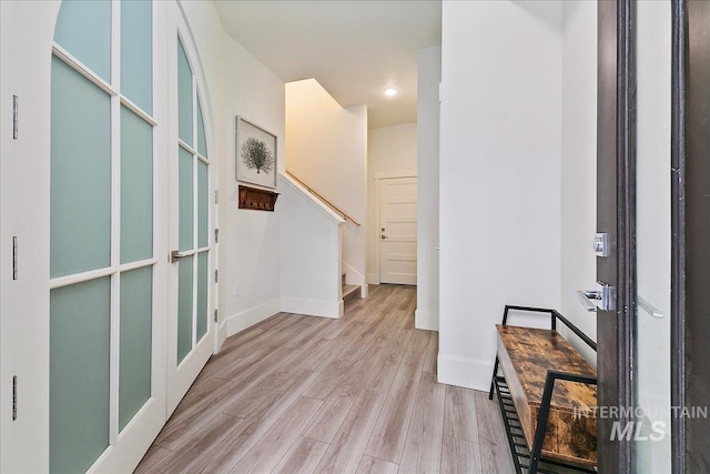 foyer featuring stairs, wood finished floors, and baseboards