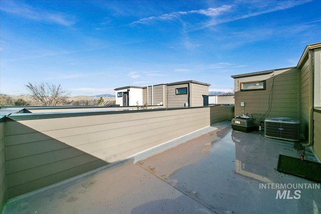 view of side of property with central AC and fence