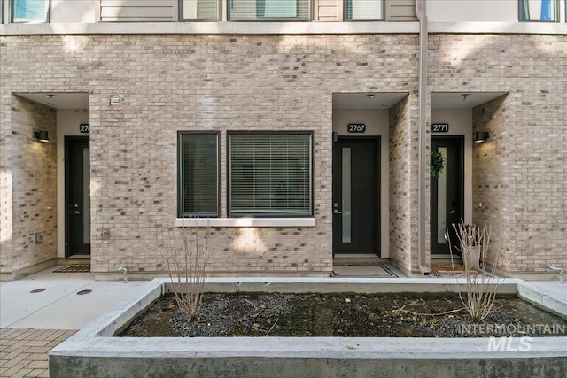 doorway to property with brick siding