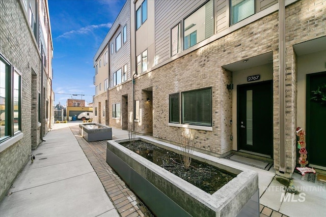 exterior space with brick siding and an outdoor fire pit