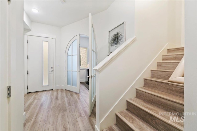 foyer entrance featuring stairway and wood finished floors