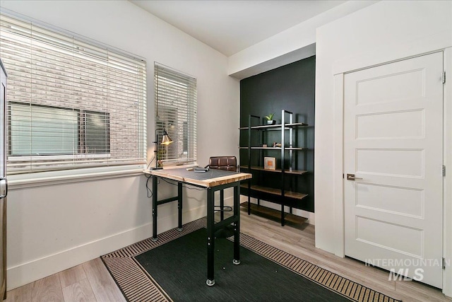 office space with wood finished floors and baseboards