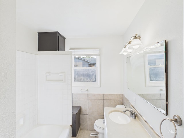 2624 Iowa Ave, Caldwell, ID 83605 - full bathroom featuring tile walls, vanity, wainscoting, tub / shower combination, and tile patterned flooring