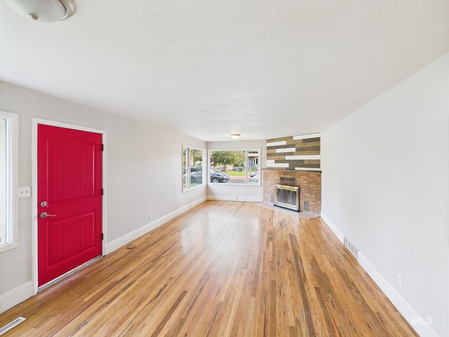 2624 Iowa Ave, Caldwell, ID 83605 - unfurnished living room featuring light wood-style floors and a brick fireplace