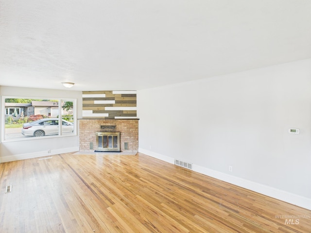 2624 Iowa Ave, Caldwell, ID 83605 - unfurnished living room with wood finished floors and a brick fireplace