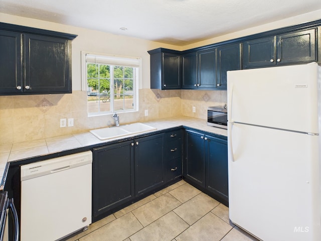 2624 Iowa Ave, Caldwell, ID 83605 - kitchen featuring white appliances, tile counters, backsplash, and light tile patterned floors