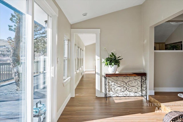 corridor with hardwood / wood-style flooring and lofted ceiling