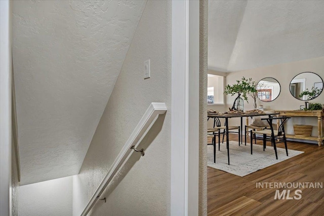 staircase with hardwood / wood-style flooring and vaulted ceiling