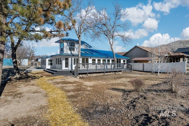 rear view of property featuring a deck and a lawn