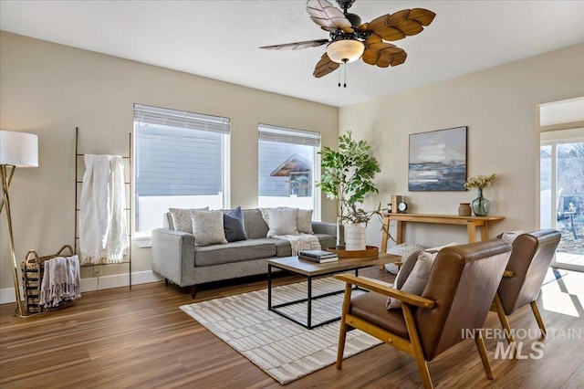 living room with ceiling fan and dark wood-type flooring