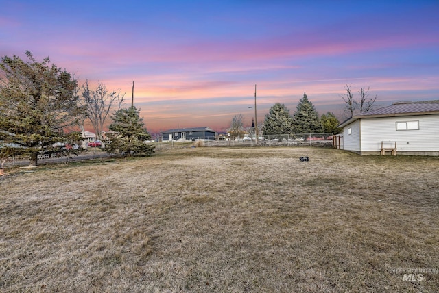 yard at dusk featuring fence