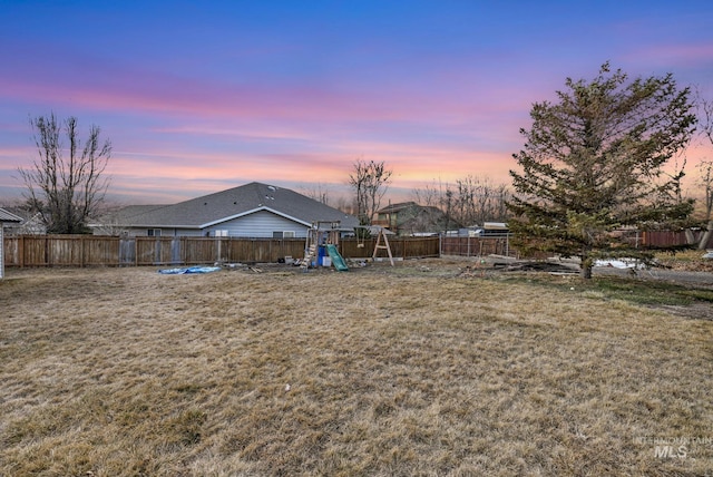 view of yard featuring a fenced backyard and a playground