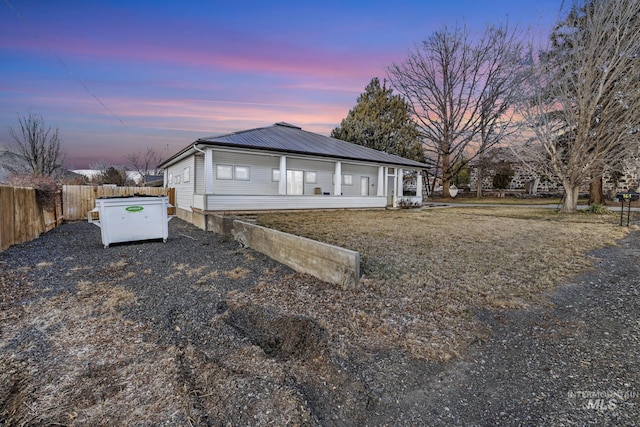 view of front of home featuring fence and metal roof