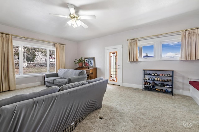 living area with carpet floors, ceiling fan, and baseboards