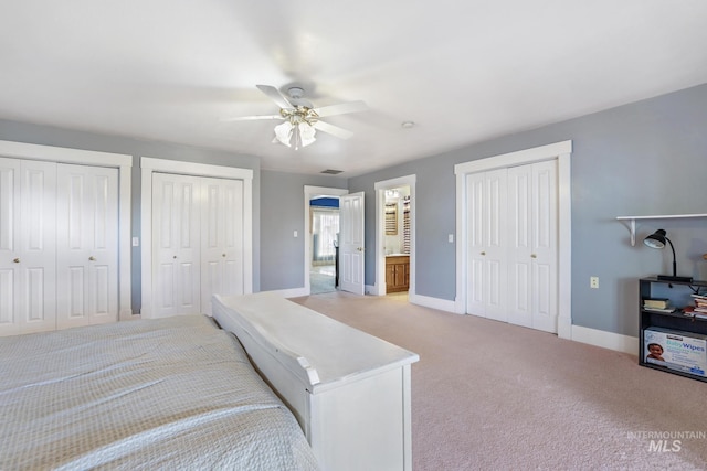 bedroom featuring light colored carpet, a ceiling fan, baseboards, visible vents, and multiple closets