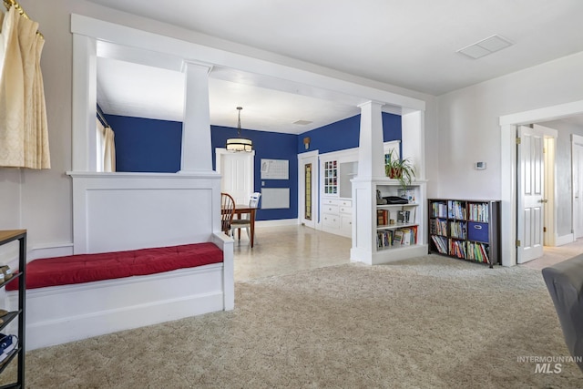 carpeted bedroom featuring decorative columns and baseboards