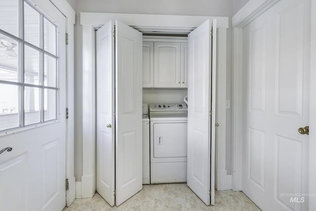 washroom with washer and dryer and cabinet space