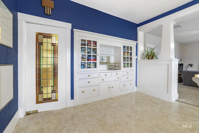 interior space featuring carpet floors and ornate columns