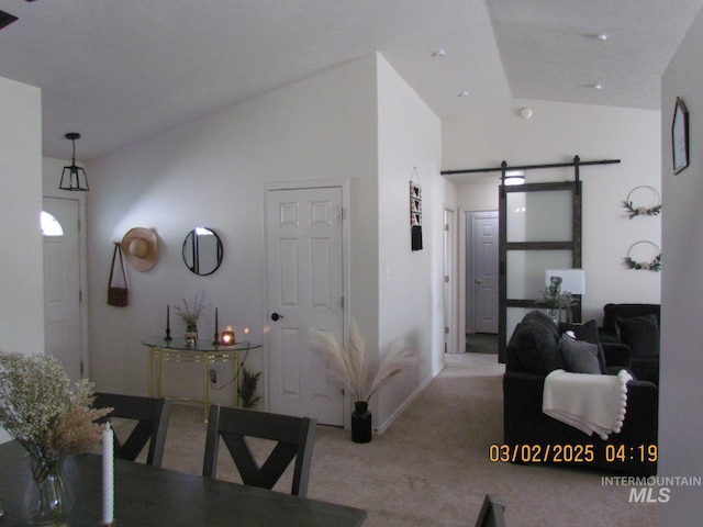 corridor featuring high vaulted ceiling, carpet, and a barn door