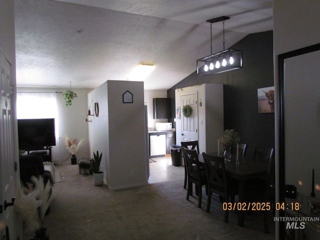 carpeted dining space with vaulted ceiling