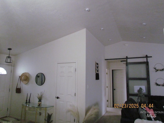 foyer featuring vaulted ceiling and a barn door