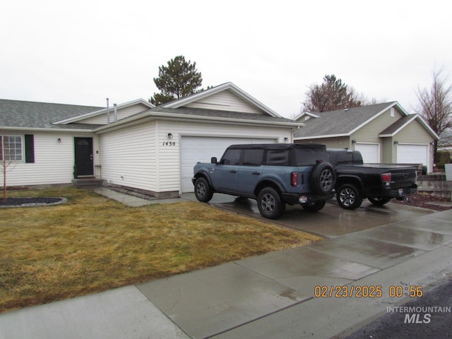 view of front of house with an attached garage, entry steps, driveway, and a front yard