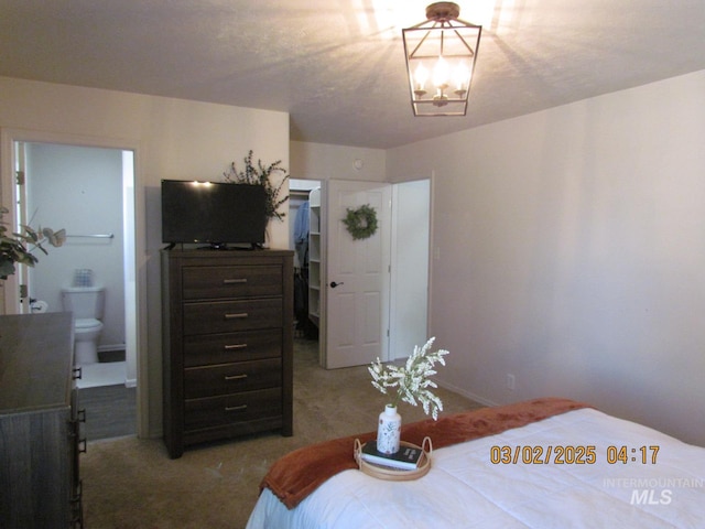 bedroom featuring ensuite bath and an inviting chandelier