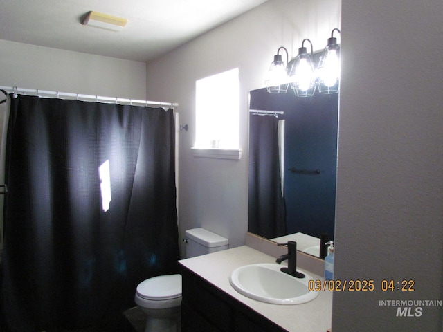 bathroom featuring toilet, a shower with shower curtain, and vanity