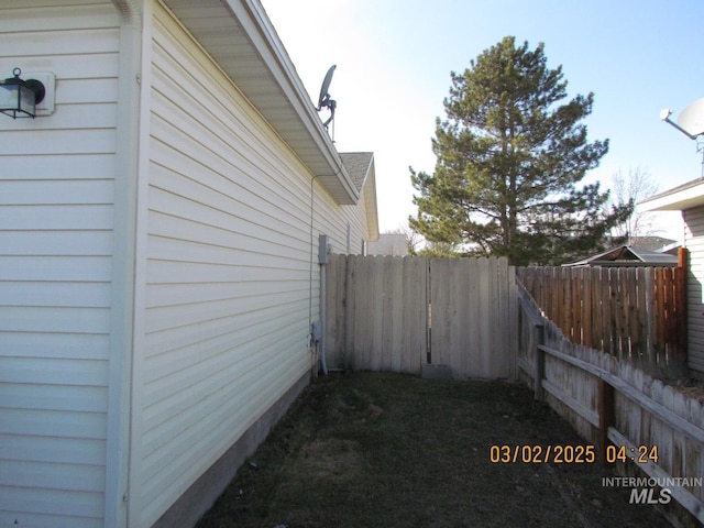 view of side of home featuring fence