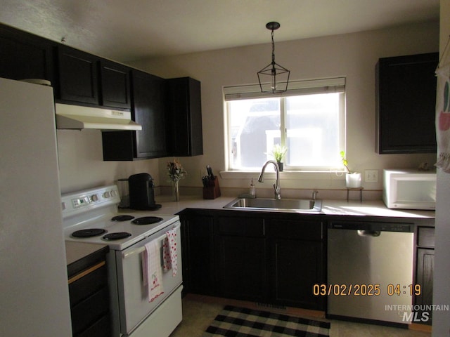 kitchen featuring light countertops, a sink, dark cabinets, white appliances, and under cabinet range hood