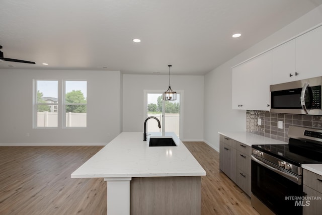 5011 S Amorita Ave, Meridian, ID 83642 - kitchen with stainless steel appliances, a sink, light wood-style floors, backsplash, and open floor plan