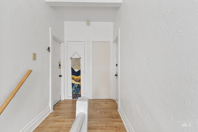 corridor featuring light wood-style floors and baseboards