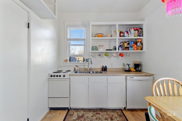 kitchen with light wood-type flooring, white appliances, light countertops, and a sink