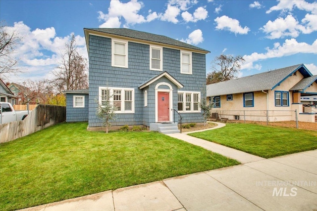 colonial inspired home featuring a front lawn and fence