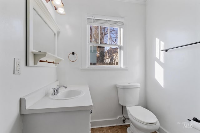 bathroom with toilet, tile patterned flooring, baseboards, and vanity